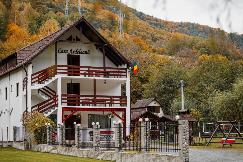 a building with a fence in front of it at Casa Ardeleana in Lotrioara