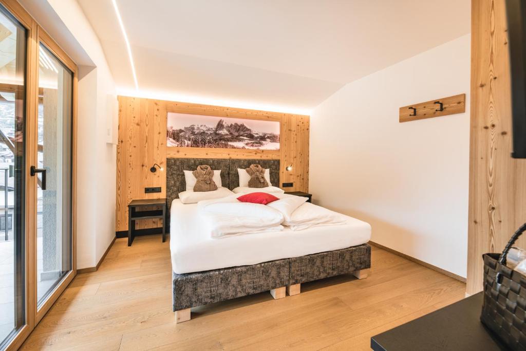 ein Schlafzimmer mit einem großen weißen Bett in einem Zimmer in der Unterkunft Residence Altea in St. Ulrich in Gröden