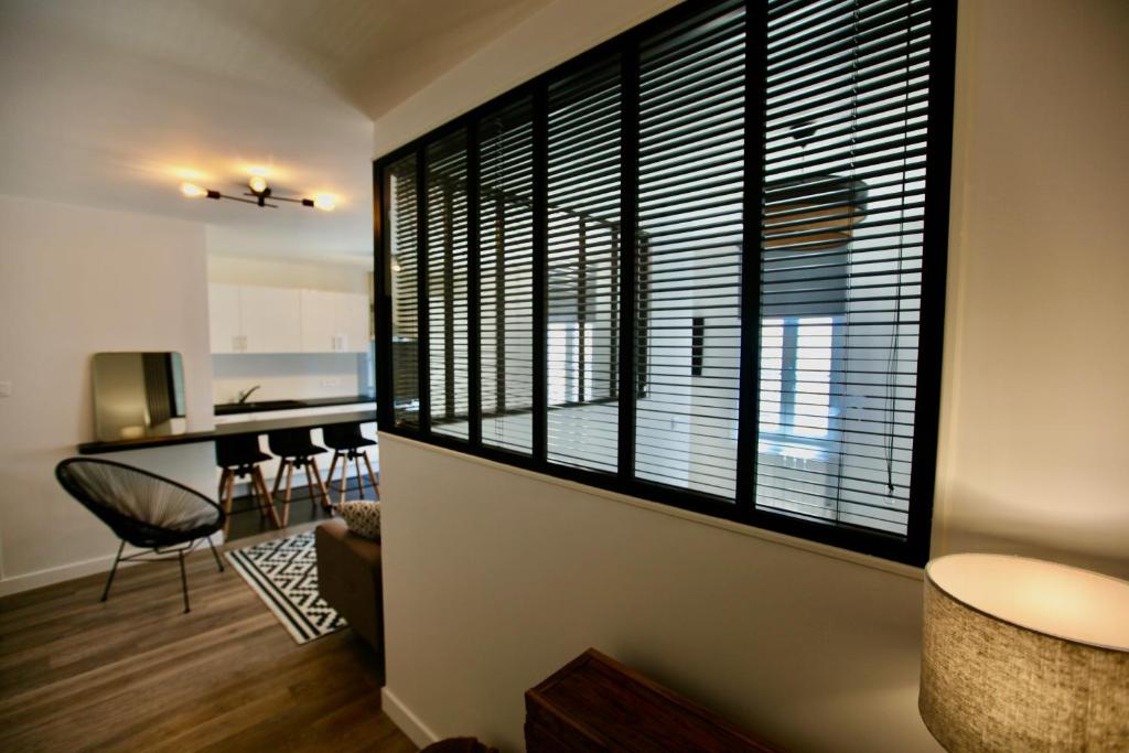 a living room with a large window and a kitchen at Le Temple in La Rochelle