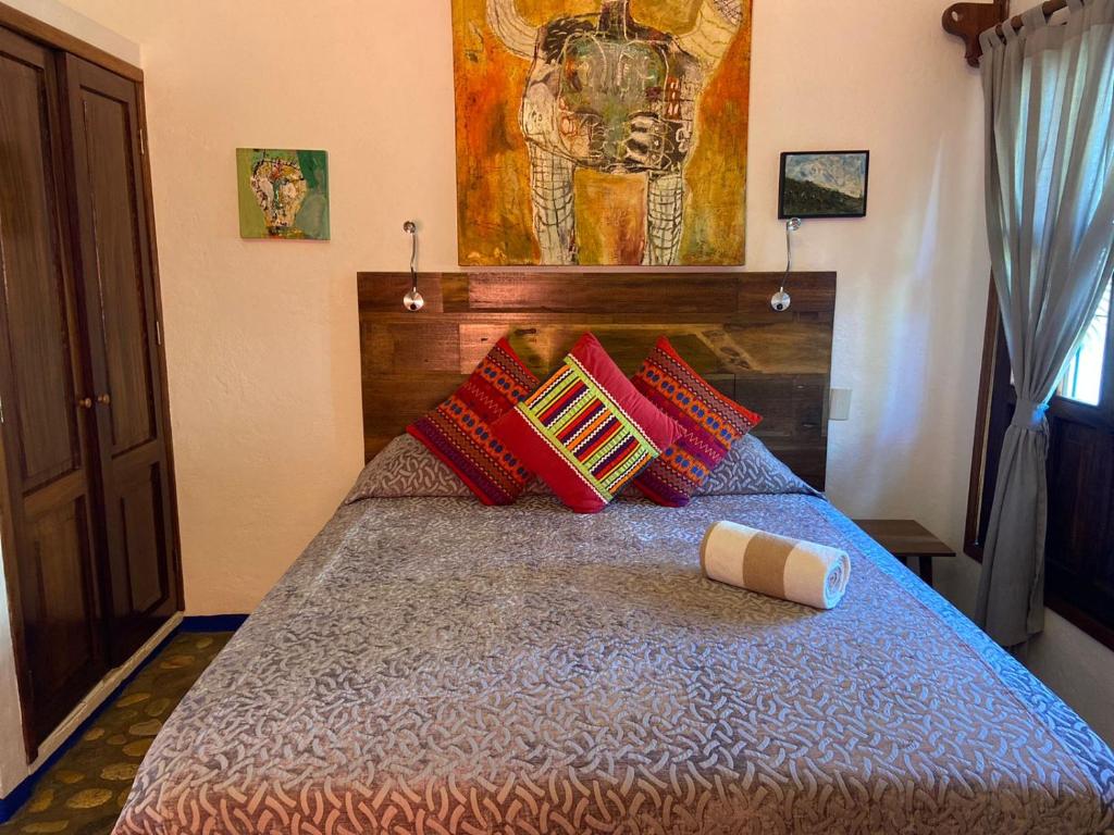 a bedroom with a bed with red pillows at Aurinko Bungalows in Sayulita