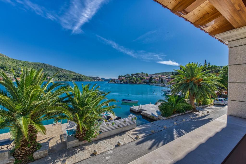 uma vista para um corpo de água com palmeiras em Adria House Dubrovnik by the sea em Zaton