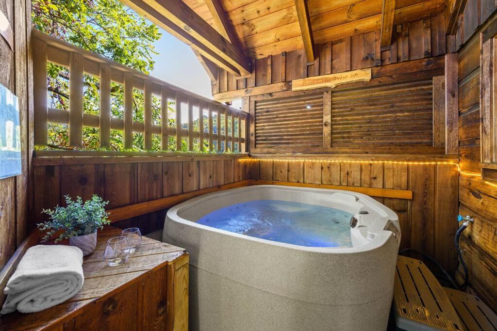 a large bath tub in a wooden house at Do Not Disturb - Pigeon Forge Smoky Mountain Studio Cabin, Hot Tub, Fireplace in Pigeon Forge