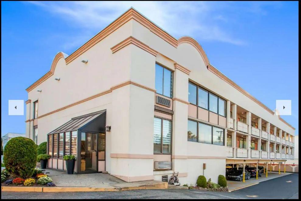 a large white building with a lot of windows at Super 8 by Wyndham Meadowlands in Carlstadt