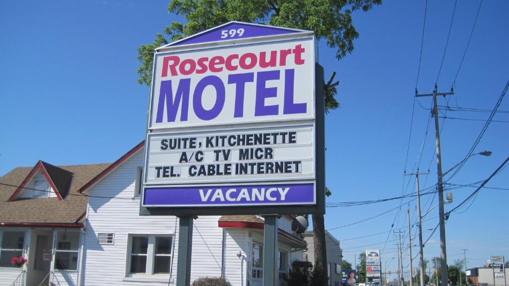 un cartello per un motel di fronte a una casa di Rosecourt Motel a Stratford