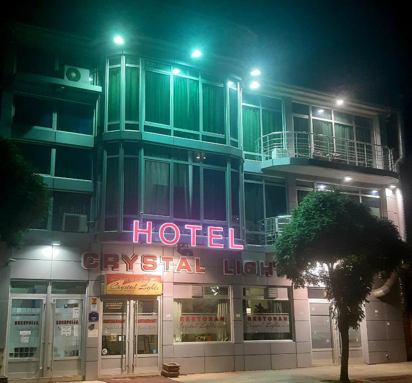 un hotel con un letrero de neón delante de él por la noche en HOTEL Crystal Lights en Pirot