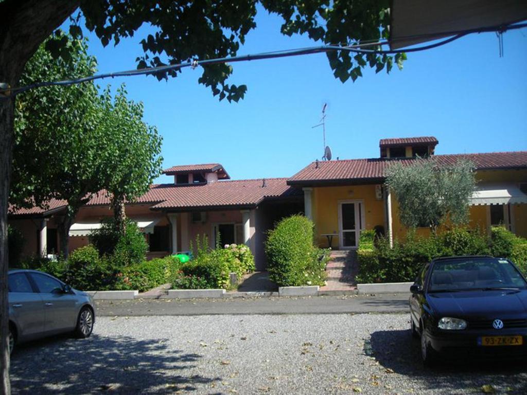 two cars parked in front of a house at Camping Wien in Peschiera del Garda