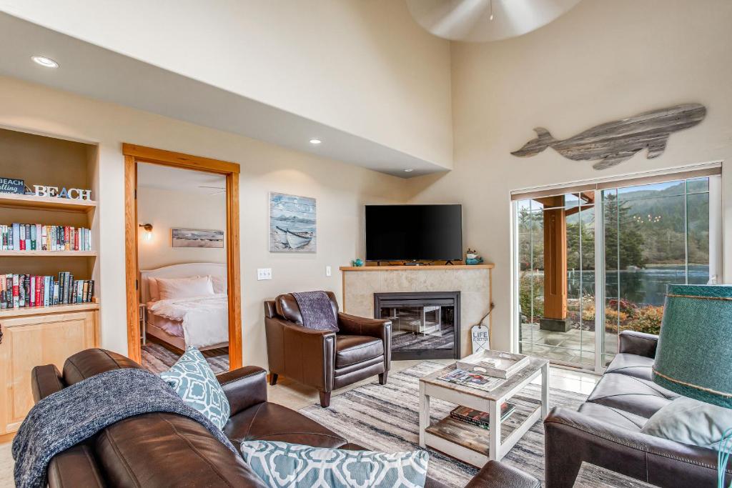 a living room with a couch and a fireplace at Howard's Lakehouse by the Sea in Rockaway Beach