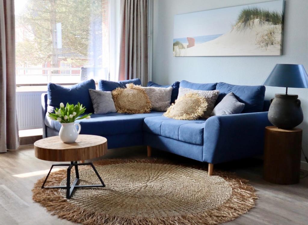 a blue couch in a living room with a table at Ferienwohnung Meersalz in Wittdün