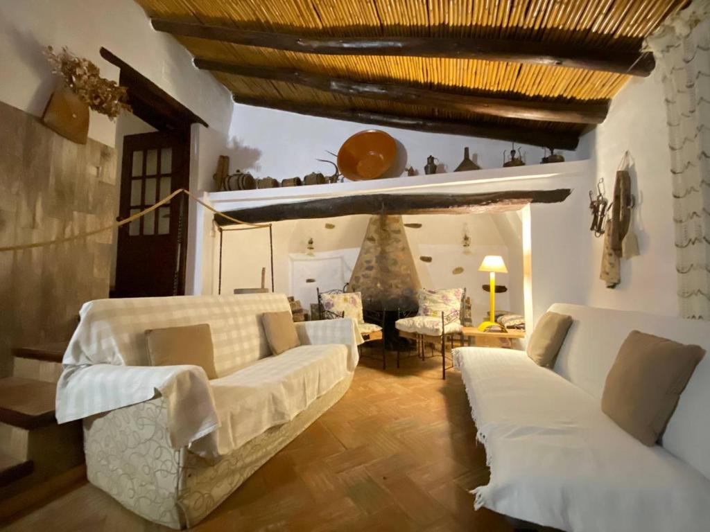 ein Wohnzimmer mit weißen Sofas und einem Tisch in der Unterkunft Monte Abaixo in Almodôvar