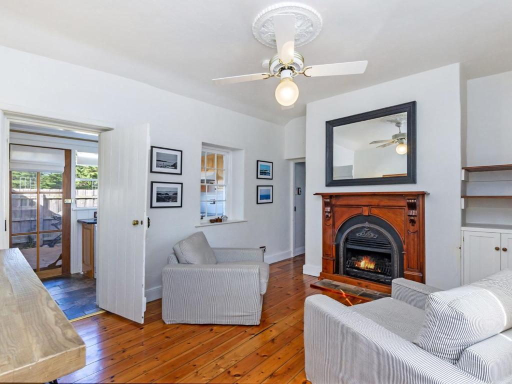 a living room with a fireplace and a couch at Pea Soup Cottage in Port Fairy