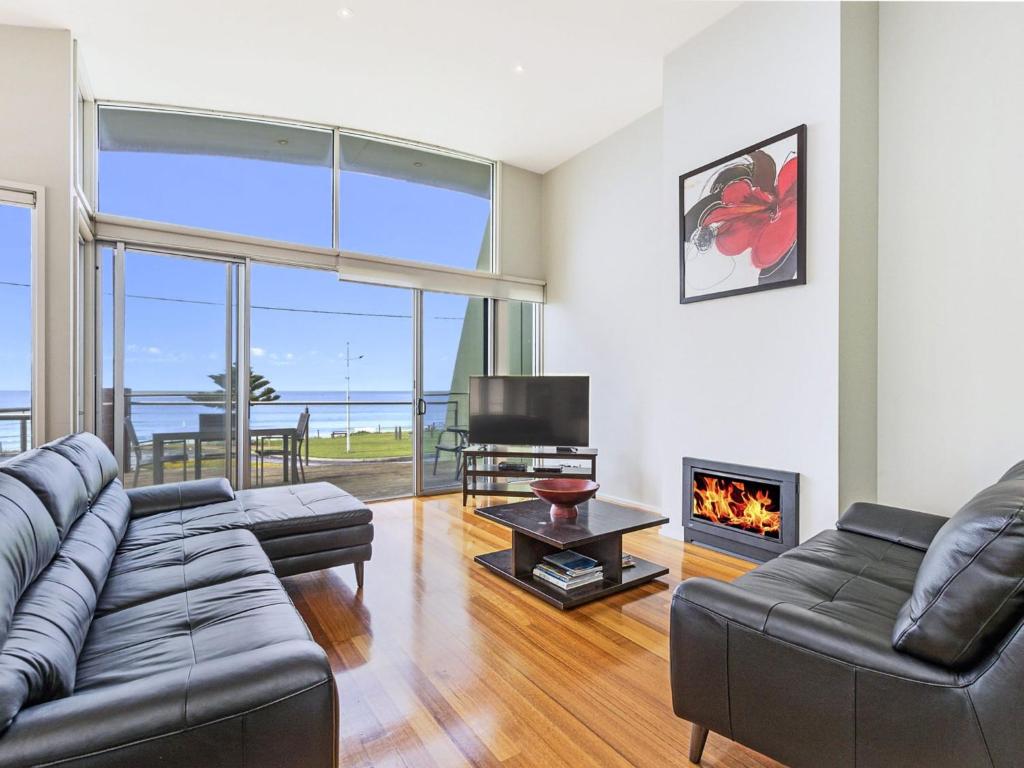 a living room with a couch and a fireplace at Shemara in Port Fairy