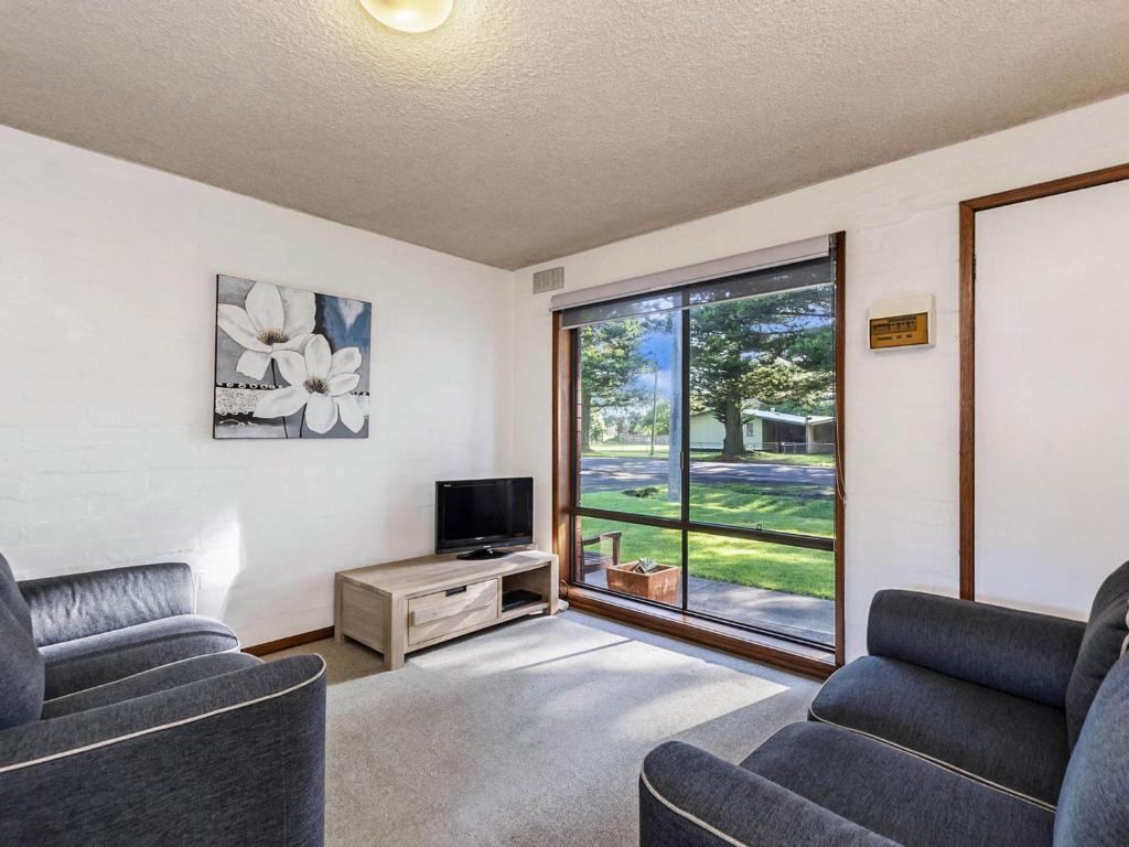 a living room with two couches and a tv and a window at Eastern Beach Unit 3 in Port Fairy