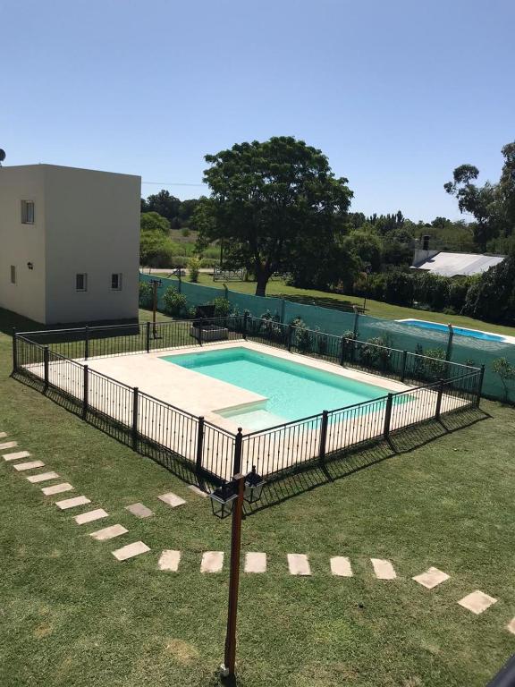 a swimming pool with a fence around it at Complejo Los Plumerillos in Chascomús