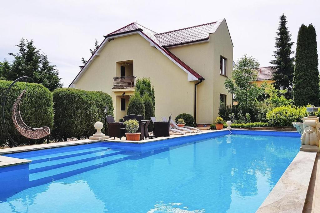 a large blue swimming pool in front of a house at holiday home, Trzesacz in Trzęsacz