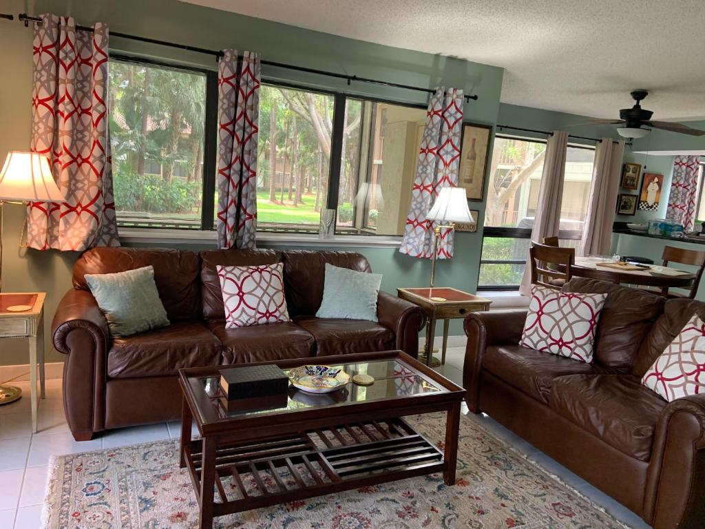 ein Wohnzimmer mit Sofas und einem Couchtisch in der Unterkunft PGA National Resort Golf Villa - Pool Side Executive Two Bedroom First Floor in Palm Beach Gardens