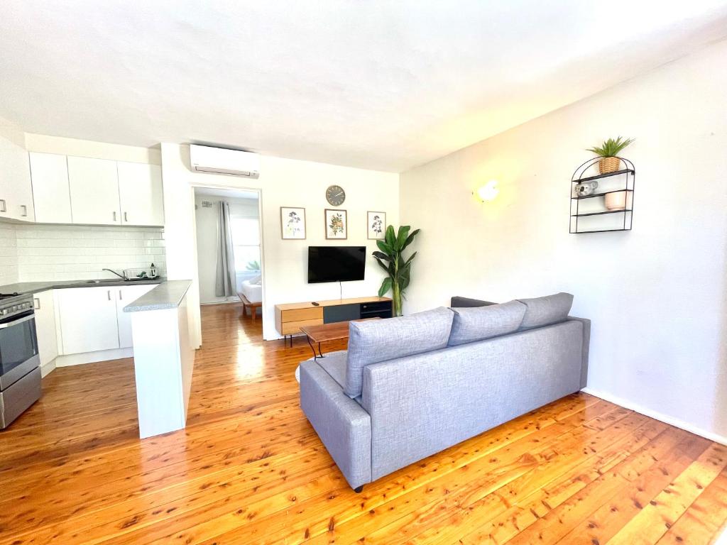 a living room with a couch and a kitchen at Lotus Stay Manly - Apartment 31B in Sydney