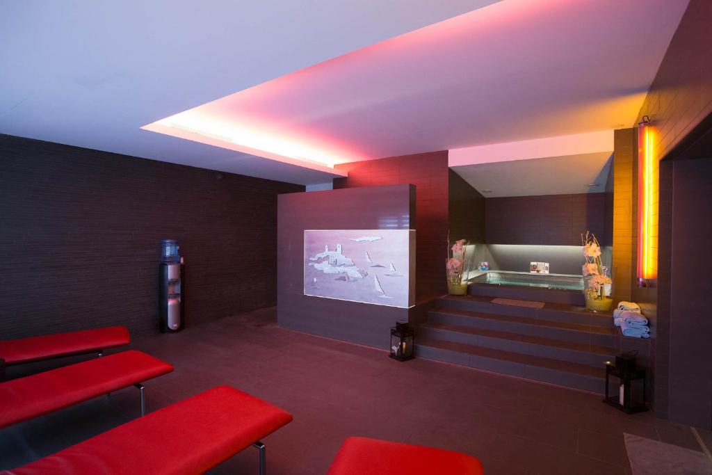 a waiting room with red chairs and a projection screen at Royal Antibes - Luxury Hotel, Résidence, Beach & Spa in Antibes