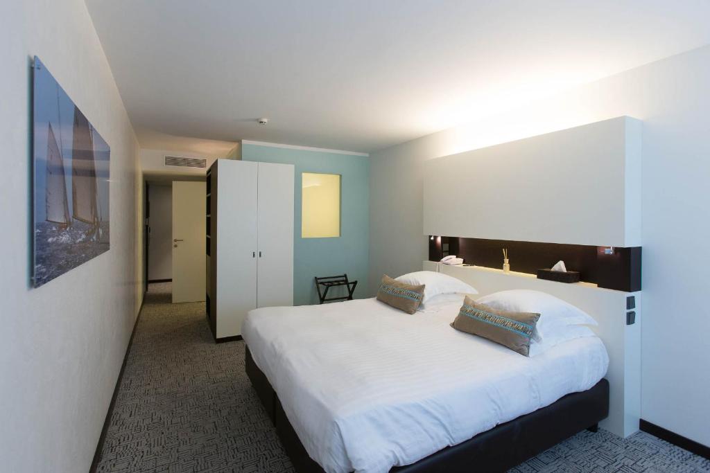a bedroom with a large bed with white sheets at Royal Antibes - Luxury Hotel, Résidence, Beach & Spa in Antibes