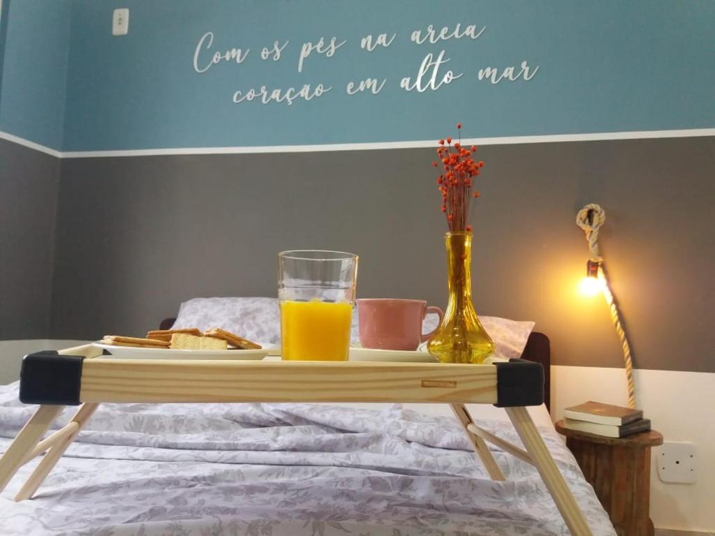 uma bandeja de sumo de laranja e pão numa cama em Estiloso 2 Quartos Wifi e SmarTV em Guarapari