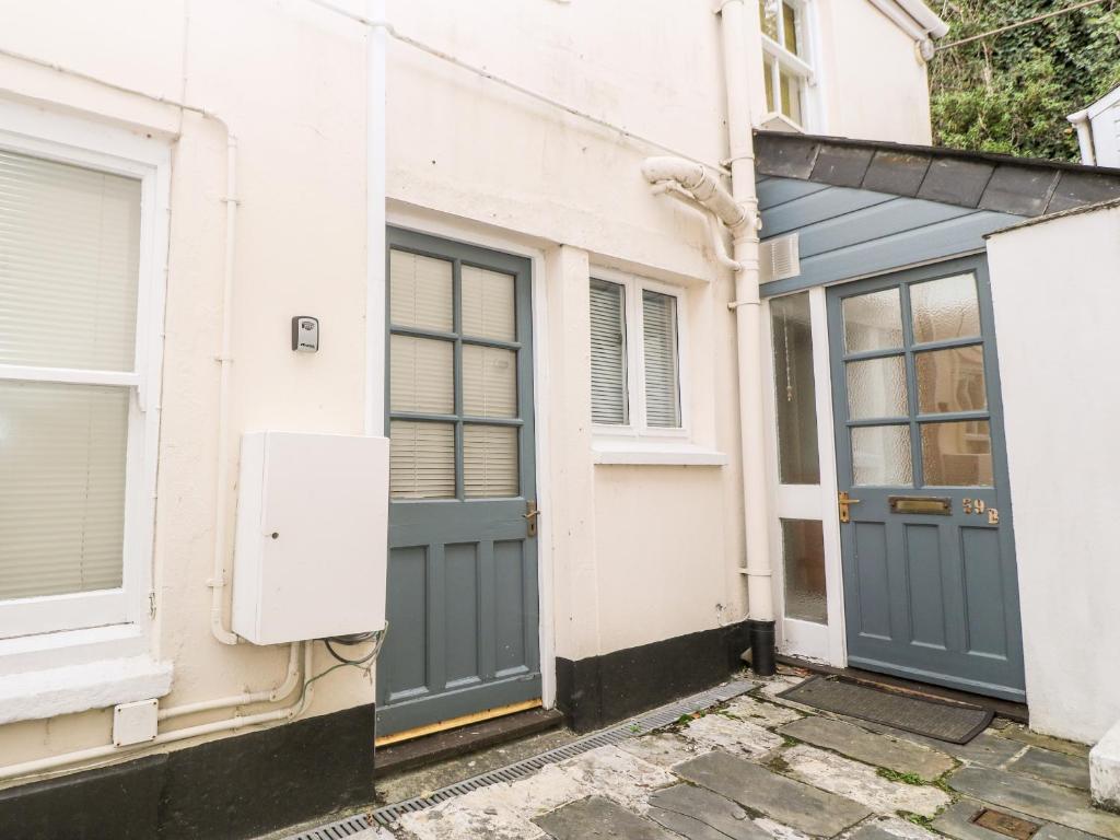 a house with a blue door and a garage at Maia House in Penryn