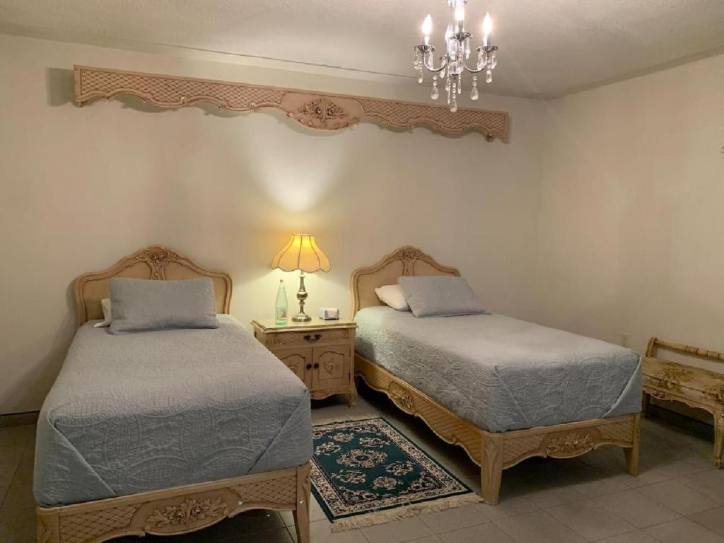 a bedroom with two beds and a chandelier at Casa Almar in Tampico
