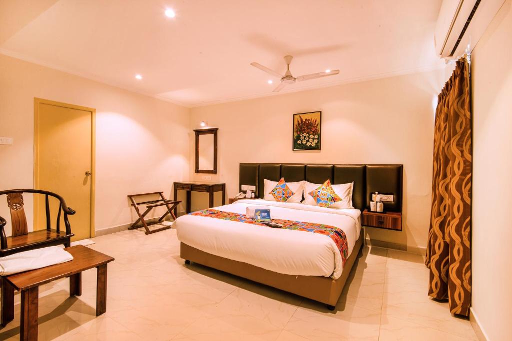 a hotel room with a large bed and a large window at FabHotel Blossoms Service Apartment in Chennai