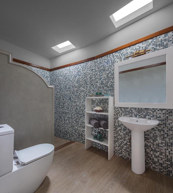 a bathroom with a toilet sink and a mirror at Green Escape Unawatuna in Unawatuna