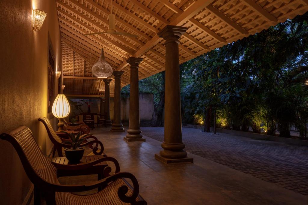 a porch with two chairs and a table and lights at Green Escape Unawatuna in Unawatuna