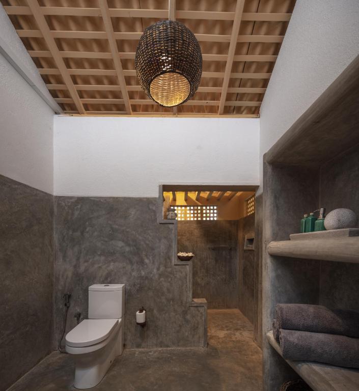 a bathroom with a toilet and a chandelier at Green Escape Unawatuna in Unawatuna
