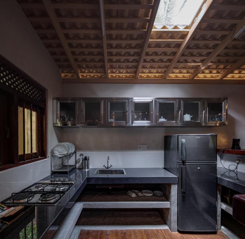a kitchen with a sink and a refrigerator at Green Escape Unawatuna in Unawatuna