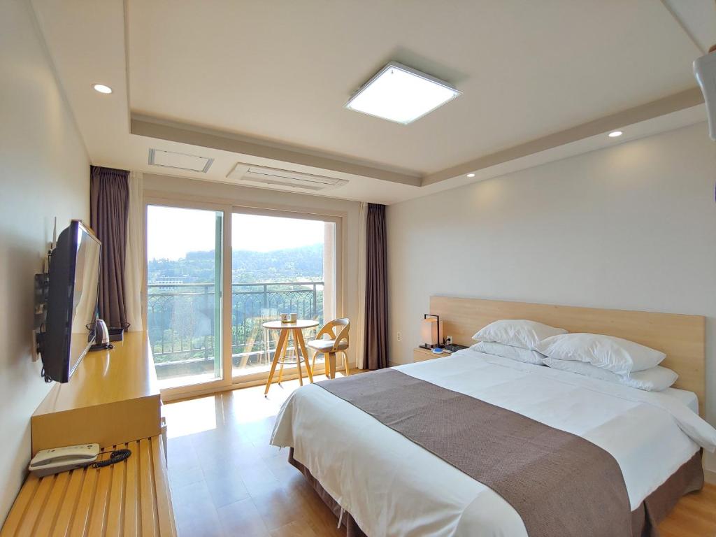A bed or beds in a room at Jeju Lavender Hotel