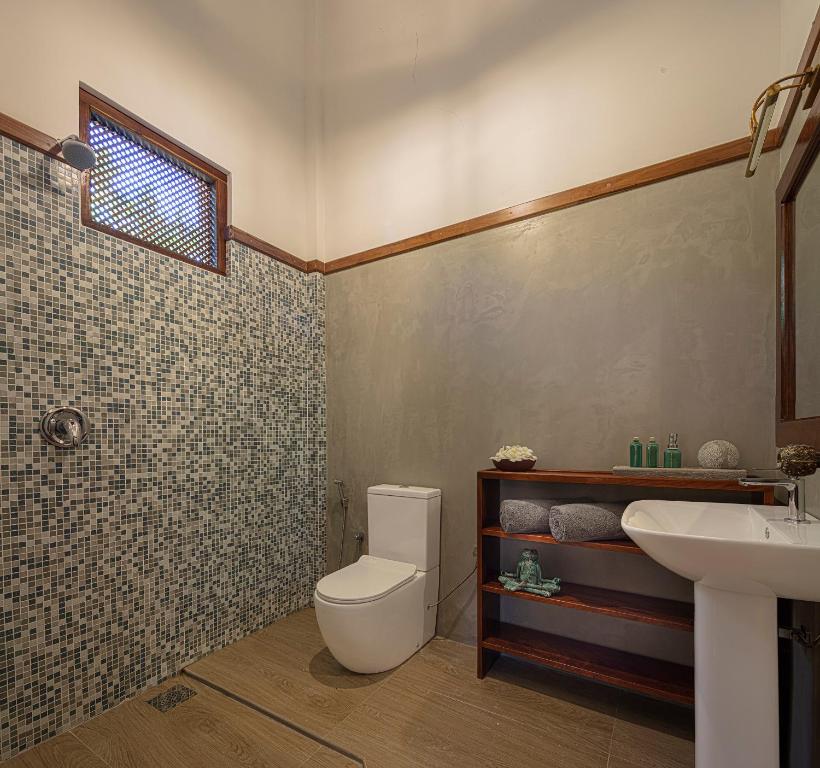 a bathroom with a toilet and a sink at Green Escape Unawatuna in Unawatuna