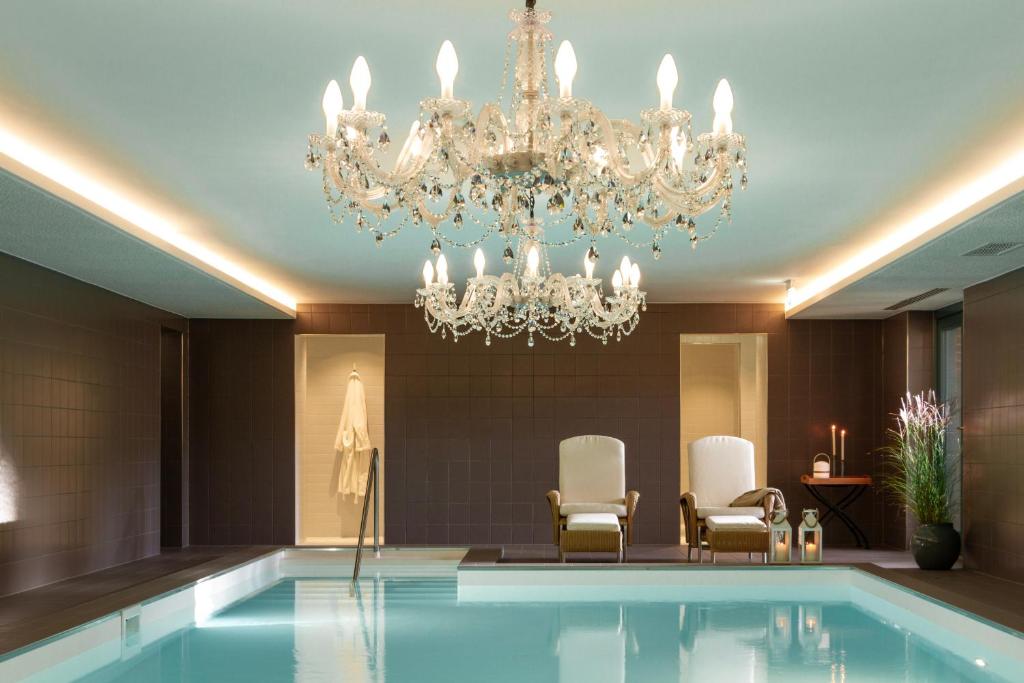 a hotel lobby with a pool and a chandelier at Gut Moorbeck in Amelhausen