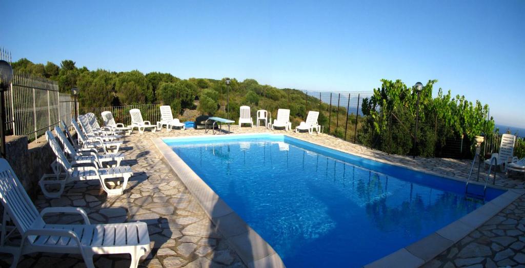 ein Pool mit Stühlen und ein paar Liegenschaften in der Unterkunft Seamoon Residence in Marina di Camerota