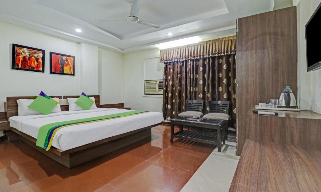 a bedroom with a bed and a chair in it at Treebo Trend Mohit Regency in Bhopal