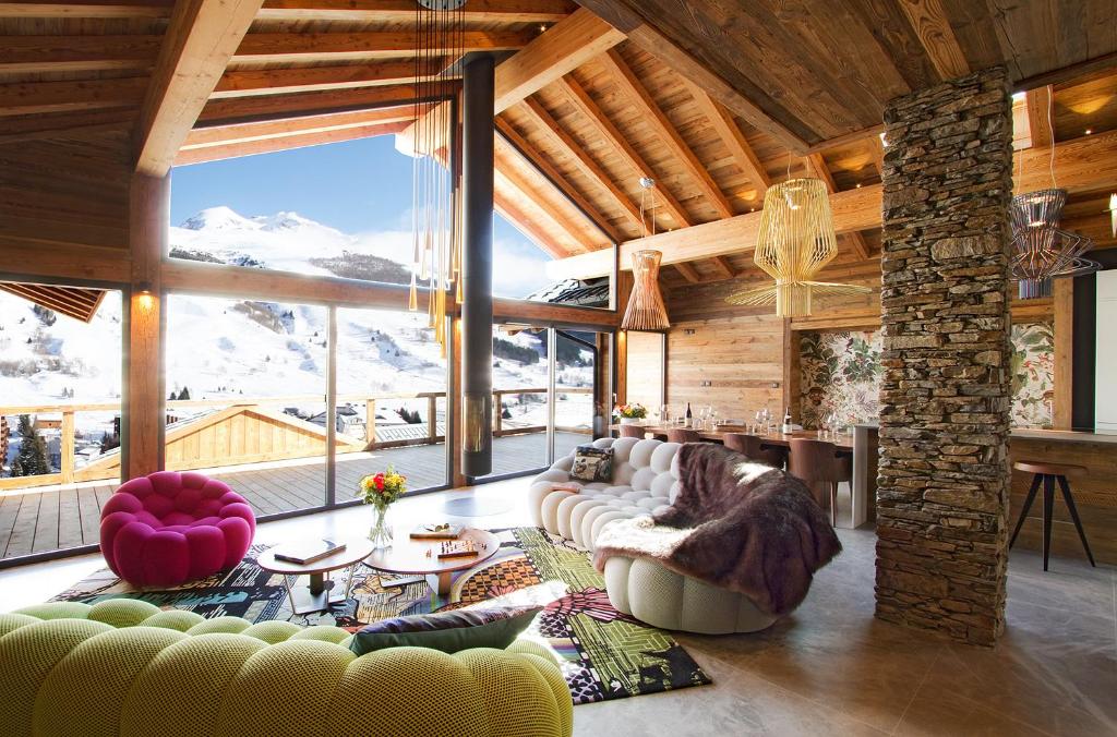 a living room with couches and a large window at Chalet le 1700 in Les Deux Alpes