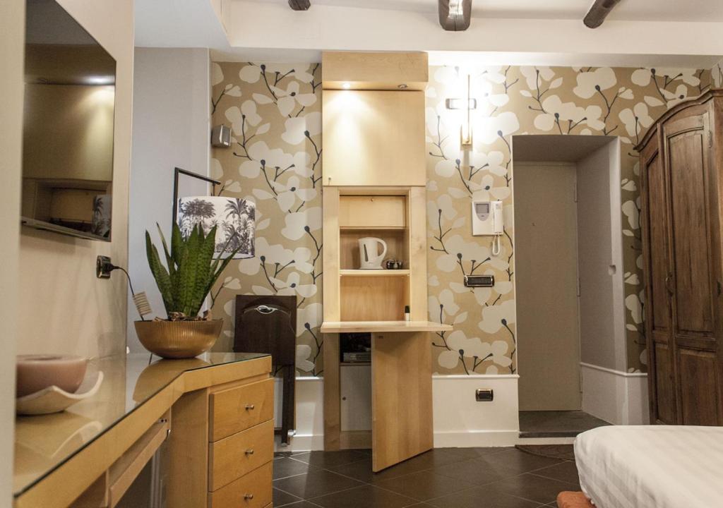 a room with a kitchen with a wall with floral wallpaper at Relais Santa Chiara in Naples