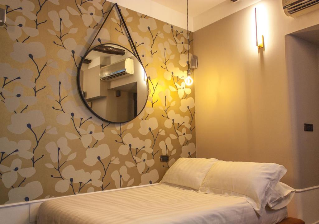 um pequeno quarto com um espelho e uma cama em Relais Santa Chiara em Nápoles