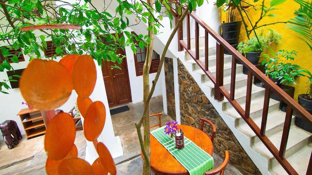 a table and chairs in a room with a staircase at Villa Yehinsa - Galle Fort in Galle