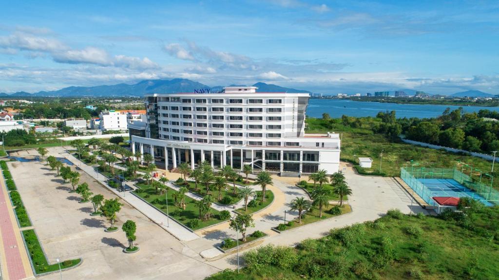an aerial view of a large white building with palm trees at Navy Hotel Cam Ranh in Cam Ranh