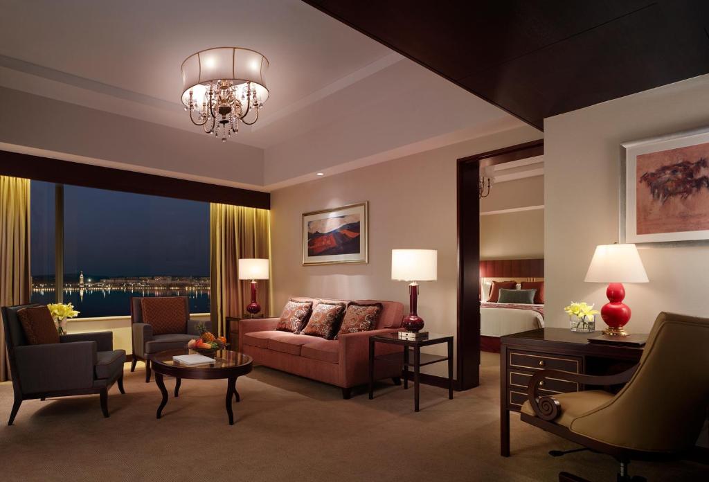 a living room with a couch and a bed at Shangri-La Manzhouli in Manzhouli
