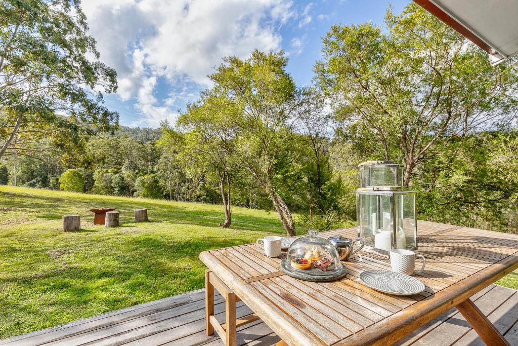 a wooden picnic table with a bowl of food on it at The Chichester Retreat in Bandon Grove