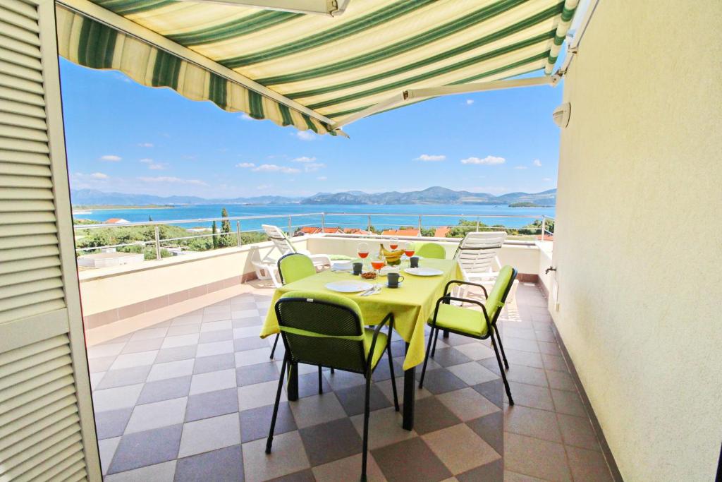 a table and chairs on a balcony with a view of the ocean at Apartments Gusti in Drače