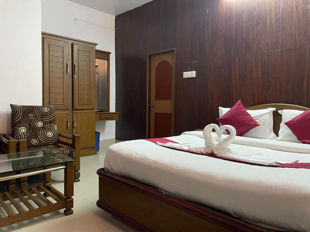 Un dormitorio con una cama con dos cisnes. en Hotel Caveri, en Madikeri