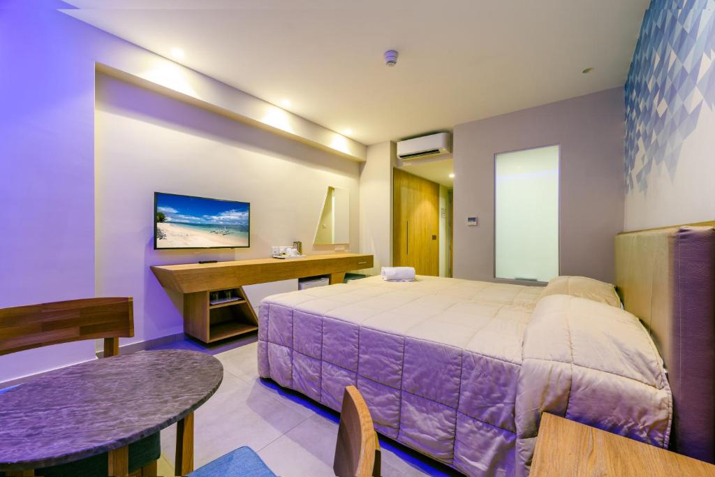 a bedroom with a bed and a desk and a table at Seasons Hotel (Adults Only) in Ayia Napa
