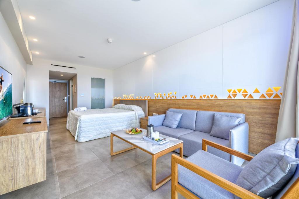 a hotel room with a couch and a bed at Seasons Hotel (Adults Only) in Ayia Napa