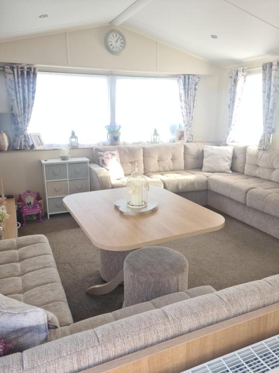 a living room with a couch and a table at The orchards holiday home in Clacton-on-Sea