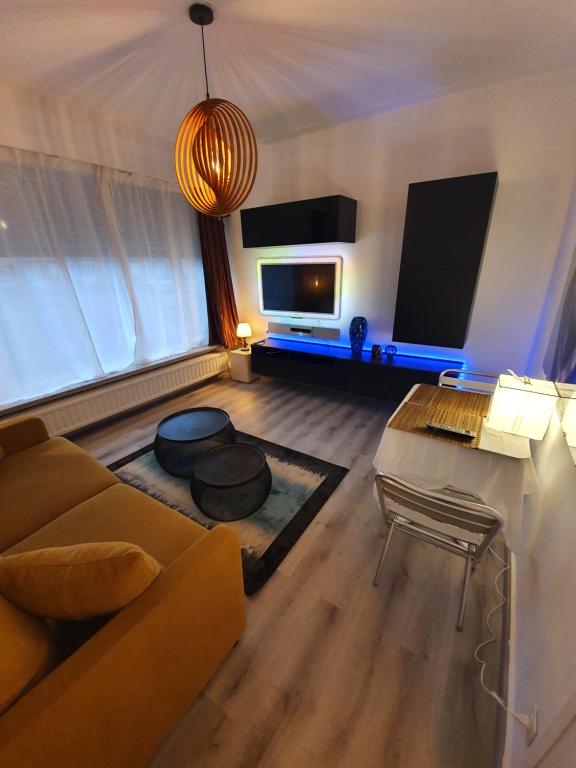 a living room with a couch and a flat screen tv at Cosy Corner Hof Van Tichelen in Antwerp