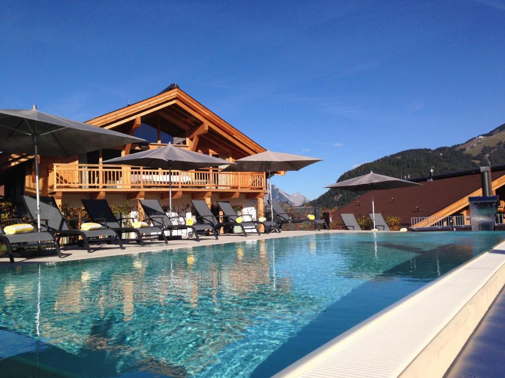 a resort with a swimming pool and a house at Mountains Hotel in Seefeld in Tirol