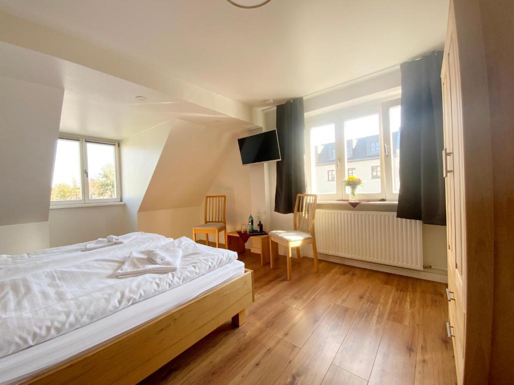 - une chambre avec un lit blanc et une fenêtre dans l'établissement Colonial Café Pension, à Werder